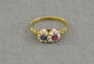 A lady's gold dress ring in the form of 2 entwined hearts set ruby and sapphire surrounded by diamonds
