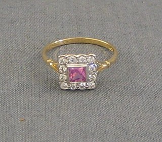 A lady's gold dress ring set a square cut pink sapphire surrounded by 12 diamonds