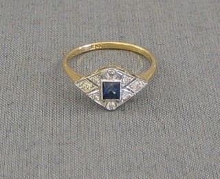 A lady's gold dress ring set a square cut sapphire surrounded by 3 diamonds and other smaller diamonds