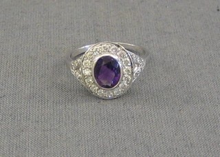A lady's gold dress ring set an oval cut amethyst surrounded by diamonds