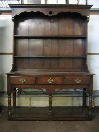 An Antique style oak dresser, the raised back with moulded cornice, fitted 2 shelves, the base fitted 3 drawers, raised on turned supports with pot board 60"