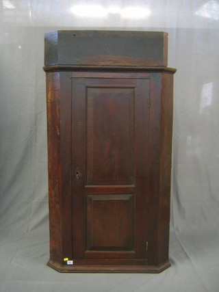 An oak corner cabinet with moulded cornice and panelled door 31"