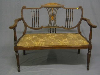 An Edwardian inlaid mahogany double chair back settee raised on turned and reeded supports