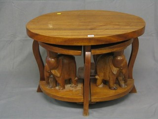 An oval Eastern carved hardwood nest of coffee tables, raised on elephant supports 29"