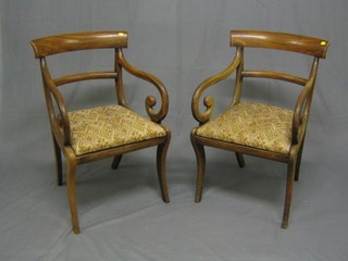 A pair of Regency bar back open arm desk chairs with plain mid rails and upholstered drop in seats, raised on sabre supports