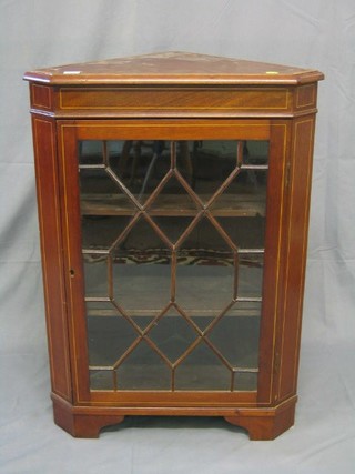 A 19th Century inlaid mahogany corner cabinet, the interior fitted shelves enclosed by an astragal glazed panelled door, raised on bracket feet 25"