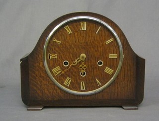 A 1930's 8 day chiming mantel clock contained in an arched oak case