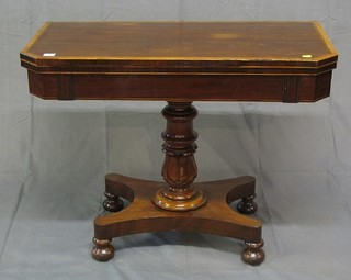A 19th Century lozenge shaped mahogany card table the crossbanded top inlaid ebony stringing, raised on a turned column with triform base 36"