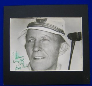 A black and white photograph of Bing Crosby with golf club, signed Every good wish Bing Crosby 7" x 9"