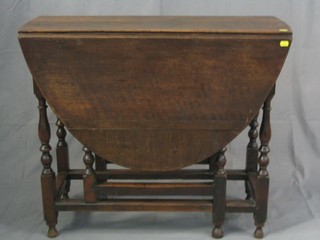 An 18th Century oak oval gateleg dining table fitted a frieze drawer and raised on turned supports 34"