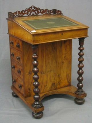 A Victorian walnutwood Davenport with inset tooled leather writing surface and pierced three-quarter gallery, the pedestal fitted an inkwell drawer and 4 long drawers with tore handles, raised on bobbin turned supports 22"