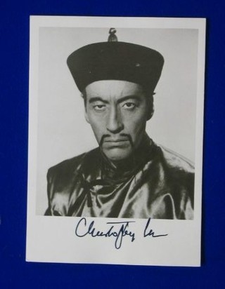 A signed black and white photograph of Christopher Lee in costume as Foo Man Chu