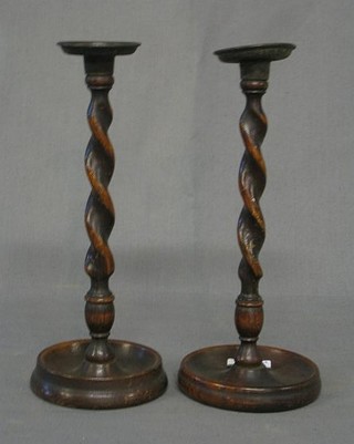 A pair of spiral turned oak candlesticks with metal sconces 10"