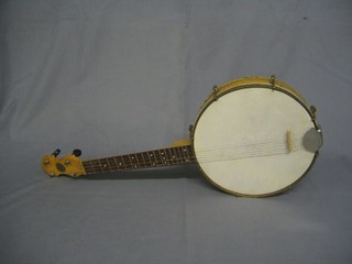 A 4 stringed banjo with enclosed back and 11" drum by John Gray & Sons