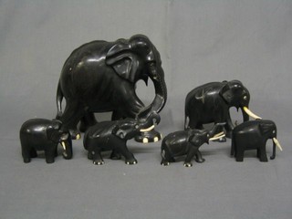 A group of 7 ebony and ivory elephants