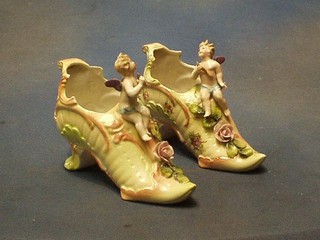 A pair of 19th Century German porcelain ornaments in the form of lady's shoes decorated cherubs 6"