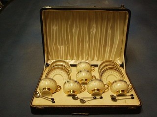 A Continental porcelain coffee service with 6 cups and saucers, black and gilt banding and Grecian key decoration together with 6 silver bean end coffee spoons, cased