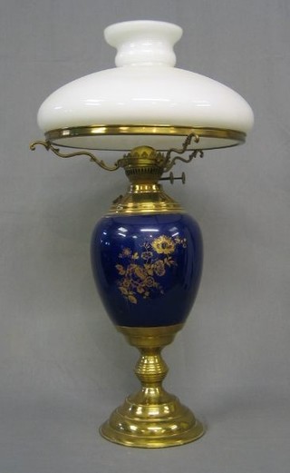 A 19th Century garter blue porcelain oil lamp reservoir with gilt and floral decoration and gilt metal mounts, with clear glass shade