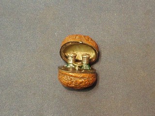 A lady's 19th Century  carved walnut scent bottle holder, the interior with silver plated mounts revealing 2 miniature cut green glass perfume bottles with stoppers and a funnel