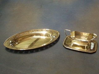 An Art Deco silver plated sauce boat and stand and an oval pierced silver plated dish, monogrammed N, 12" (2)