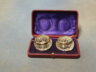 A pair of cut glass circular salts with silver rims and spoons, Birmingham 1911, cased