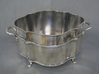 An oval shaped silver plated twin handled wine cooler with bead work decoration, raised on 4 hoof feet 12"