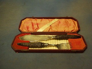 A pair of silver plated fish servers with stag horn handles, cased