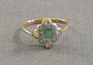 A lady's gold dress ring set a rectangular cut emerald and 4 diamonds