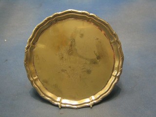 A circular silver plated salver with bracketed border raised on ball and claw supports by Mappin & Webb 9"