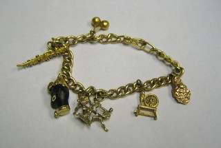 A 9ct gold charm bracelet hung 6 charms - maraccas, dagger, head, limboist, spinning wheel and a nugget