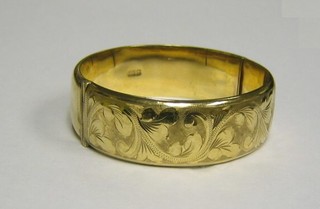 An engraved hollow 9ct gold bangle