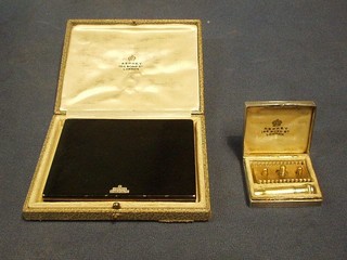 A handsome Art Deco silver gilt and black enamelled lady's cigarette case with diamonte mount, London 1935 with Jubilee hallmark, contained in original leather fitted case, together with an Art Deco Continental engine turned silver and blue enamelled travelling razor case, the hinged lid revealing a fitted interior complete with a lady's gilt metal safety razor, the lid marked Asprey's 166 Bond Street
