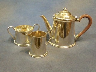 A 3 piece silver plated tea service of cylindrical form with gadrooned border, comprising teapot, twin handled sugar bowl and cream jug