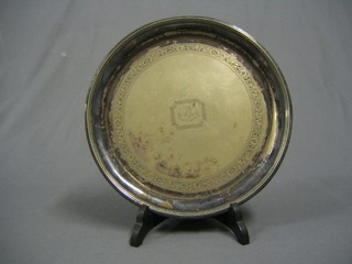 A circular silver plated salver with armorial decoration on panel supports