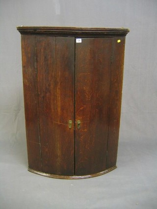 A Georgian Country oak bow front hanging corner cabinet with moulded cornice 30"