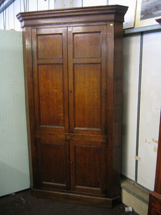 An 18th/19th Century Country honey oak double corner cabinet enclosed by panelled doors 52"