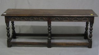 A Victorian 17th Century style carved oak rectangular stool raised on turned and block supports 48"