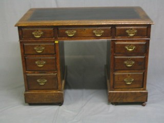 A 19th Century oak kneehole pedestal desk with inset tooled leather writing surface above 9 long drawers 42"