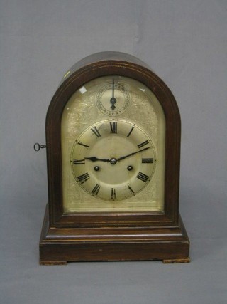 An Edwardian 8 day striking bracket clock contained in an arched mahogany case