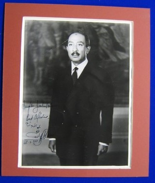 A signed black and white portrait photograph of President Sadat of Egypt, standing in a lounge suit 9" x 7"
