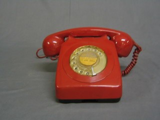 A red plastic dial telephone