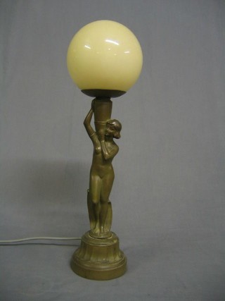 An Art Deco spelter table lamp in the form of a lady supporting a globe