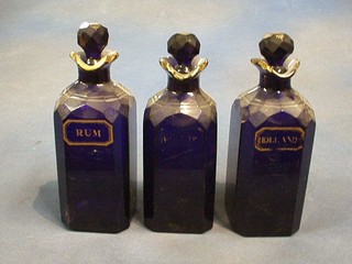 A set of 4 19th Century Bristol blue square glass decanters and stoppers marked Rum, Brandy and Hollands