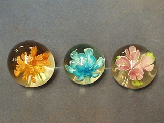 3 glass paperweights with flower head decoration