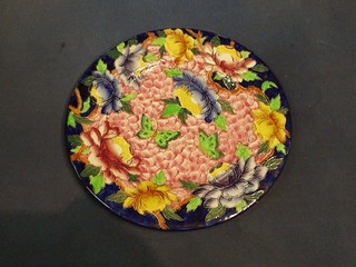 A circular Malingware pottery plate with floral and raised flower and butterfly decoration, the base marked Maling Made in England 6506P 11"