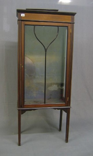 An Edwardian inlaid mahogany display cabinet, fitted adjustable shelves, enclosed by an astragal glazed panelled door, raised on square tapering supports 23"