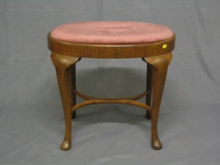 A walnutwood oval dressing table stool with upholstered drop in seat with X framed stretcher raised on cabriole supports