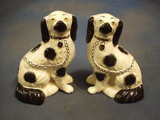 A pair of reproduction Staffordshire figures of black and white seated Spaniels 9"