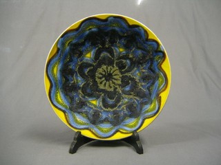 A circular yellow Poole Pottery plate, marked Poole England 10 1/2"