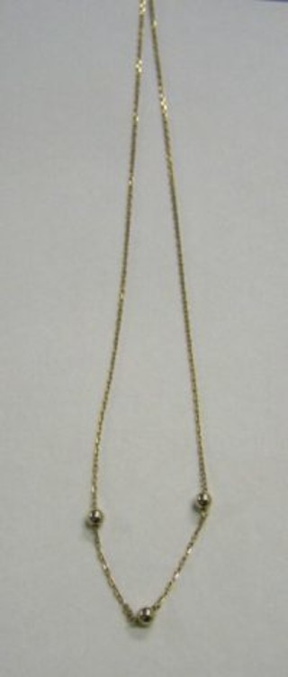 A lady's 9ct gold chain interspaced 3 spheres